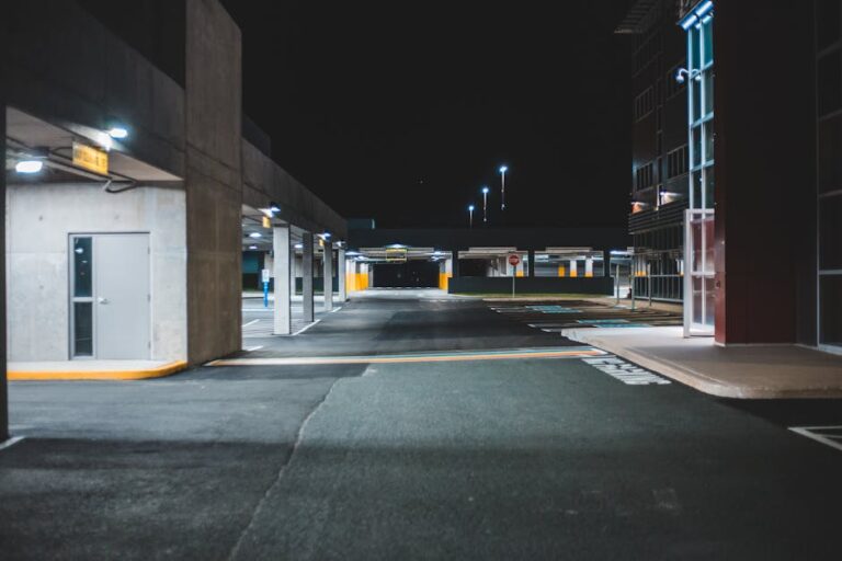 Empty urban parking lot illuminated at night with modern architecture.