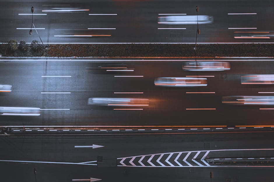 Blurred night traffic on highway, captured from above, showcasing urban speed and motion.
