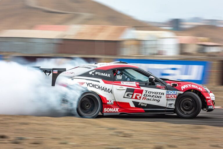 A high-speed drift racing car emits smoke from its tires on a racetrack.