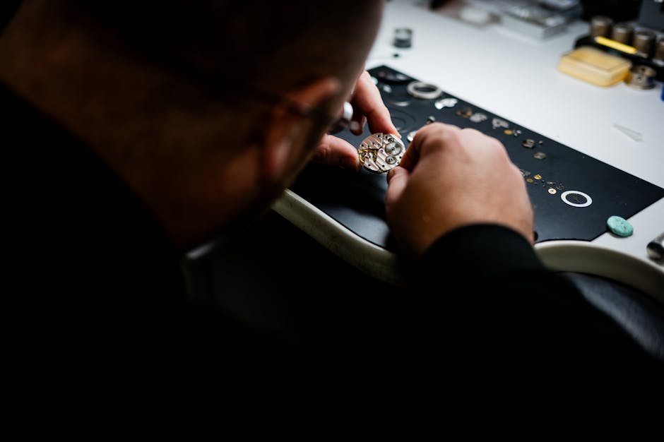 A meticulous watchmaker examines and assembles intricate watch gears at a workstation.