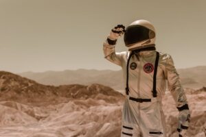 An astronaut in a silver spacesuit explores a rocky desert landscape, suggesting a sci-fi theme.