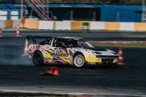A dynamic shot of a race car drifting on a track, showcasing speed and precision.