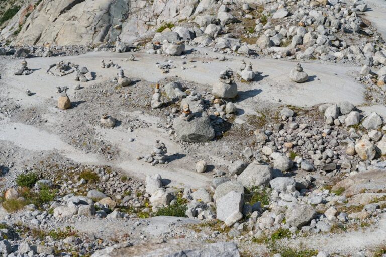 Stone cairns on a rugged, rocky landscape in the Swiss outdoors under daylight.