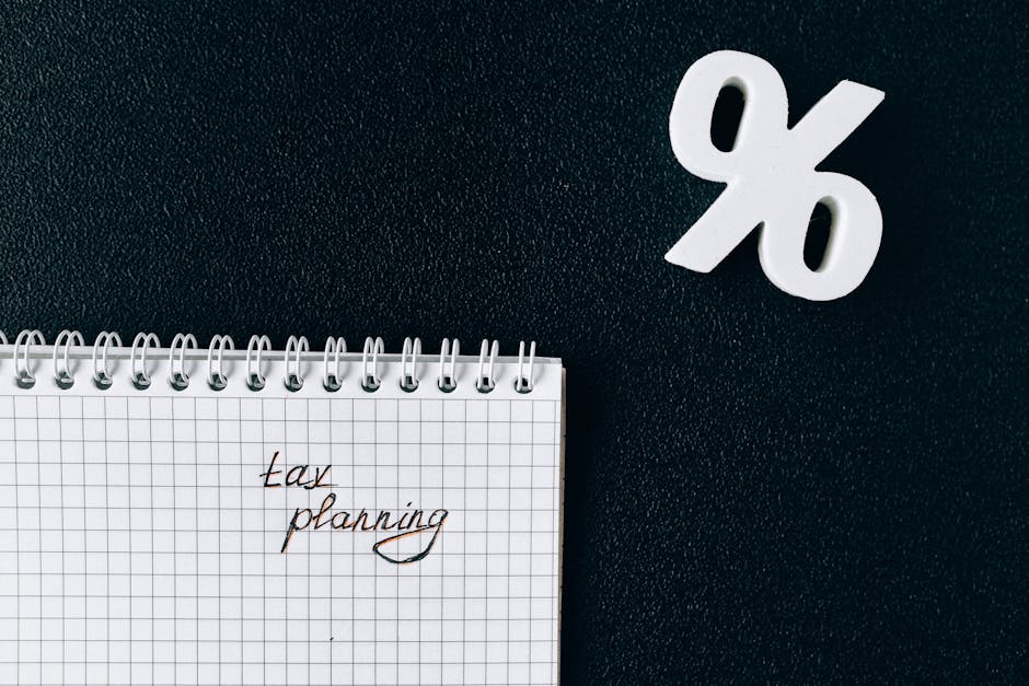 A notebook with 'tax planning' written on a grid paper next to a percent symbol on a black background.